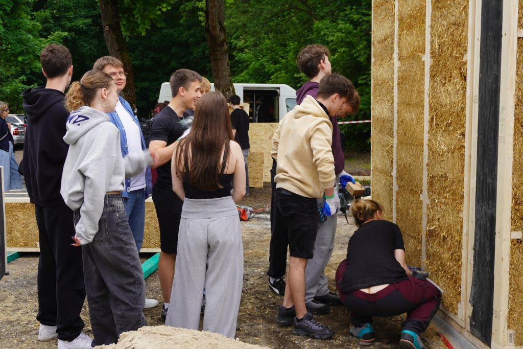 Prace uczestników przy budowie ściany z materiałów naturalnych